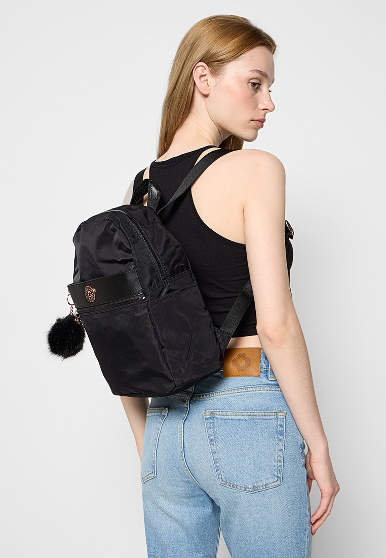 Zaino in nylon nero dalla forma arrotondata, con tasca anteriore con zip e un accento in pompon di finta pelliccia. Presenta spallacci regolabili e finiture in pelle.