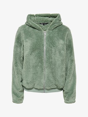 Pehme, heleroheline kapuutsiga lukuga jakk, millel on pikad varrukad ja sametine, karvane tekstuur, varustatud soonikkoega ääre ja ees lukuga sulgemisega.