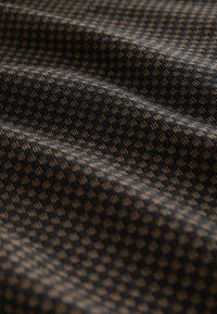 Woven fabric featuring a dark blue and light beige checkered pattern; texture appears soft with subtle sheen and depth.