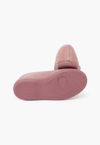 Zapato de ante rosa con punta redondeada, suela de goma texturizada y detalle de costura visible en la parte trasera. Diseño plano, sin cordones.