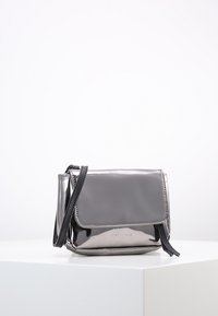 Borsa a tracolla nera lucida con chiusura a patta, caratterizzata da una tracolla testurizzata e design elegante e moderno. Elementi metallici evidenziano i bordi.