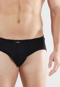 Zwarte herenonderbroek van zachte stof, met een low-rise ontwerp, stiksels en een klein logo-label op de tailleband.