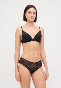 Soutien-gorge noir avec une finition lisse et des détails en dentelle sur les bords, associé à des culottes en dentelle assorties arborant des motifs floraux.