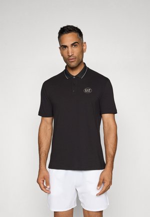 Polo shirt nero con una vestibilità slim, maniche corte, colletto e una rifinitura bianca a contrasto. Presenta un logo ricamato sul lato sinistro del petto.