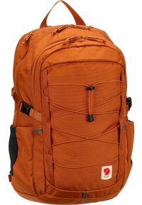 Sac à dos en tissu orange avec plusieurs compartiments, accents noirs, bretelles réglables et un cordon élastique à l'avant.