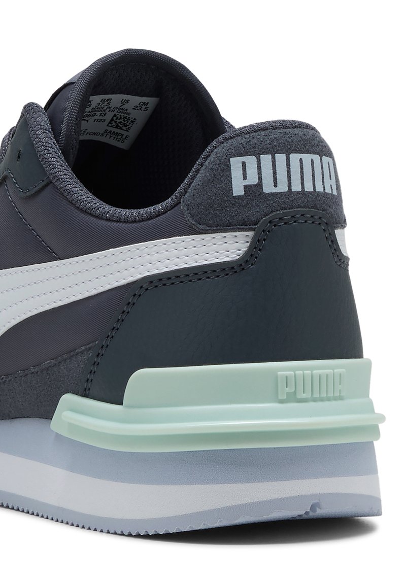 Zapatillas PUMA con parte superior de cuero y malla en gris oscuro, franjas blancas y acentos de media suela en verde menta. Presenta un talón texturizado y una marca distintiva.