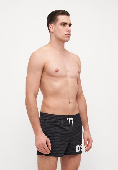 Shorts de bain noirs avec un motif texturé et le logo "DS" en blanc. Fabriqués en matériau léger, avec une taille à cordon de serrage et une longueur au-dessus du genou.
