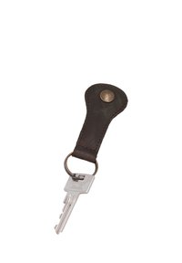 Une clé en argent unique attachée à un porte-clés en cuir marron foncé avec un bouton en laiton sur fond blanc.