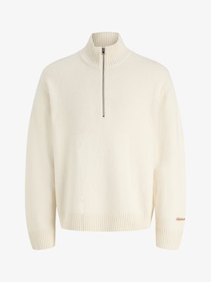 Kreemjas pikkade varrukatega kampsun soonikkoega kõrge krae, pooltõmbluku sulgemisega ning soonikkoega varruka- ja alläärtega, millel on varrukal väike tikitud tekst.