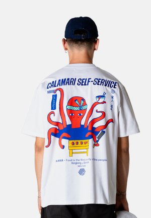 Mand iført hvid skjorte med farverig tegneserieblæksprutte, der laver mad ved grillen, holder skål og flækkekniv, tekst "CALAMARI SELF-SERVICE" på ryggen.
