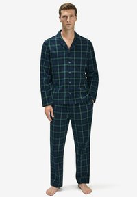 Sininen ja vihreä ruudullinen pyjama-asuste, joka on valmistettu pehmeästä kankaasta. Setti sisältää napitettavan pitkähihaisen paidan ja vastaavat löysät housut.