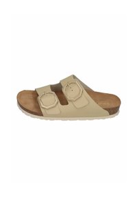 Light beige slide sandal with two adjustable octagonal straps, cork footbed, and textured rubber outsole. Flat design for comfort.