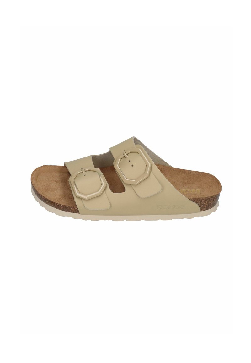 Light beige slide sandal with two adjustable octagonal straps, cork footbed, and textured rubber outsole. Flat design for comfort.