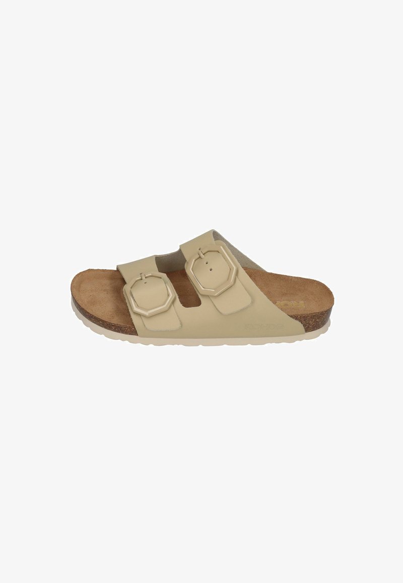 Light beige slide sandal with two adjustable octagonal straps, cork footbed, and textured rubber outsole. Flat design for comfort.
