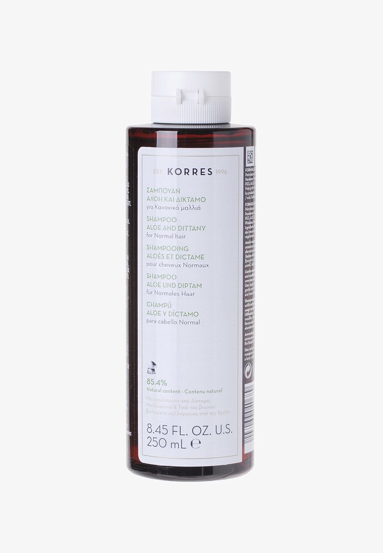 Brązowa plastikowa butelka szamponu z białą zakrętką. Etykieta zawiera tekst w wielu językach, wymieniając składniki i sposób użycia dla normalnych włosów.