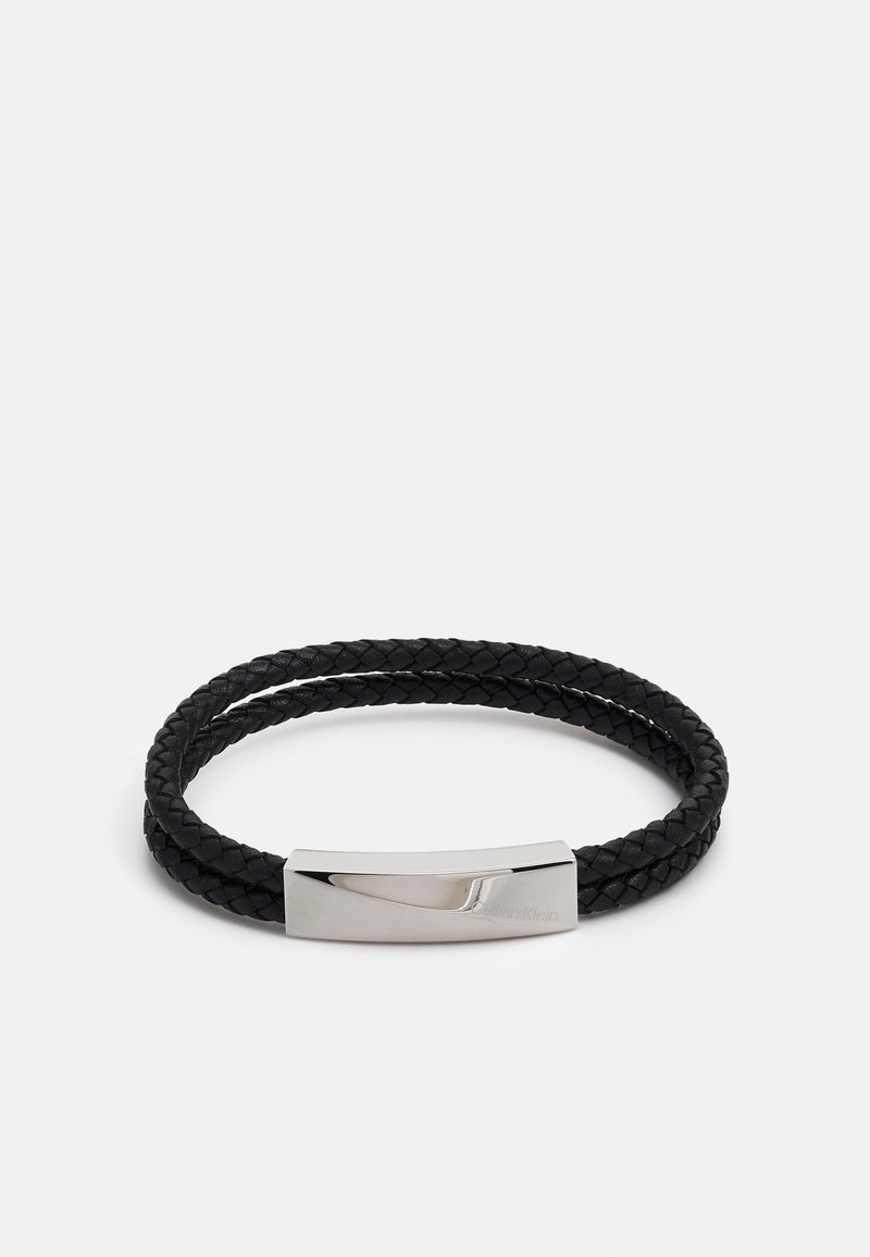 Pulsera de cuero trenzado negro con un cierre de metal en tono plateado que presenta un diseño elegante y una textura suave.