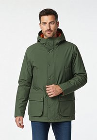 Vihreä vedenpitävä takki, jossa on huppu, napit ja kaksi etutaskua, sekä oranssi vuori. Sileä pinta ja rento istuvuus.