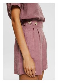 Shorts en lin mauve à taille haute, dotés de deux plis sur le devant et d'une fermeture à double bouton. Poches latérales pour plus de praticité.