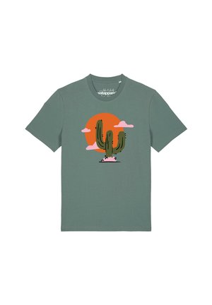 T-shirt vert à manches courtes avec un motif de cactus devant un soleil orange et des nuages roses.