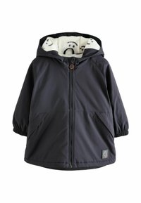 Veste noire à capuche avec fermeture éclair à l'avant, poignets élastiques et poches latérales. Doublée d'un tissu blanc doux et à motifs présentant des visages.