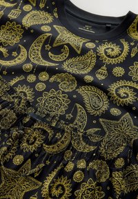 Tissu noir avec des motifs complexes de paisley doré, croissant de lune, étoile et lanterne, doté d'une taille froncée et d'un col côtelé.