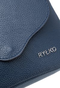 Borsa in pelle blu navy con superficie texturizzata, caratterizzata da una patta curva e un logo argentato. Le cuciture sono visibili lungo i bordi.
