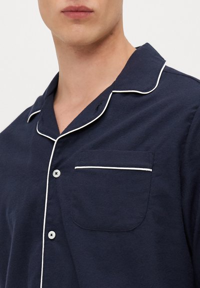 Camisa de pijama de algodão azul-marinho com colarinho em V, pipas brancas, fecho com botão e um único bolso no peito. Ajuste suave e descontraído.