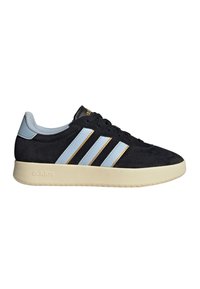 Schwarzer Adidas-Sneaker mit hellblauen Streifen, die goldumrandet sind, einer cremefarbenen Sohle und einem hellblauen gepolsterten Kragen, von der Seite auf weißem Hintergrund gezeigt.