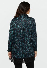 Cămașă cu imprimeu leopard negru și teal, cu guler, mâneci lungi și detalii din dantelă la tiv. Material neted cu o siluetă de croială lejeră.