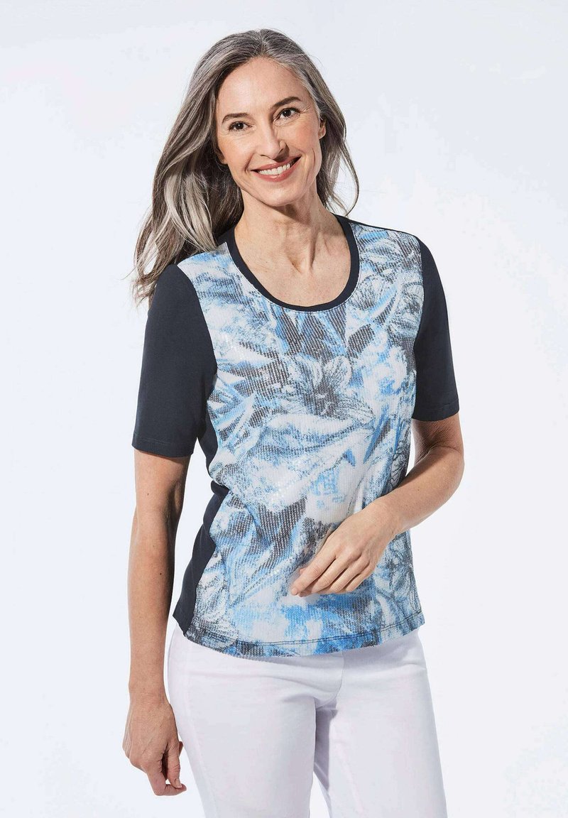 Korte mouwen top met een kleurrijk blauw-wit abstract ontwerp, afgewerkt met een zwarte bies en zijpanelen. Gemaakt van zacht, gestructureerd materiaal.