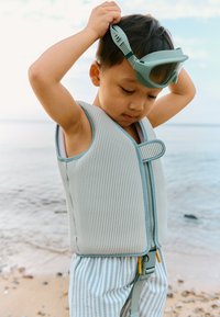 Bērnu dzīvības veste gaiši pelēkā krāsā ar vertikālām svītrām; tai ir priekšējā rāvējslēdzēja aizdare, regulējamas siksnas un drošs aizsprādzējums; mīksts, fakturēts audums.