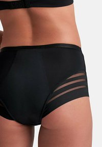 Zwarte high-waisted slips met doorzichtige strepen, zachte stof en een strakke tailleband. Beschikt over gedetailleerde stiksels voor een pasvorm die aansluit.