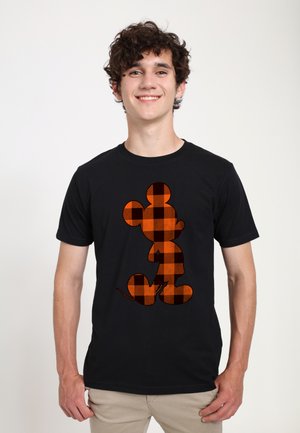 Black t-shirt featuring an orange and black plaid design of a cartoon character. The shirt has a classic crew neck and short sleeves.