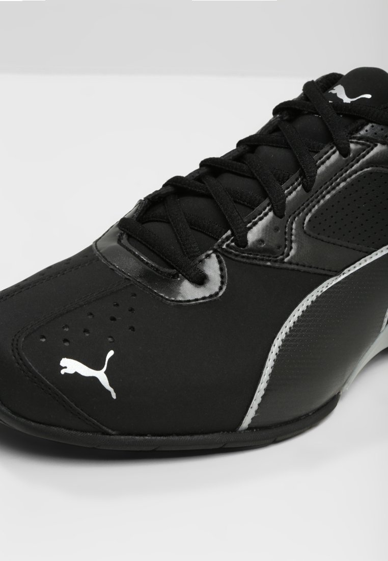 Zwarte sportieve schoen met een synthetisch bovenwerk, ademende mesh details, vetersluiting en zilveren accenten, met een gestreepte zijpaneel en logo.