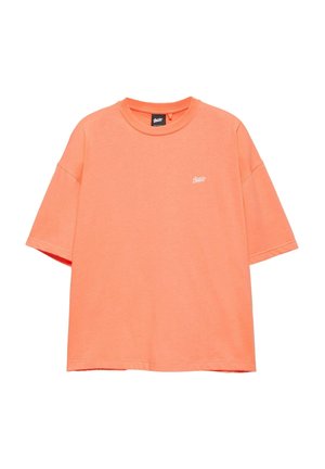Jasno oranžové tričko s krátkym rukávom a okrúhlym výstrihom s malým bielym logom na ľavej strane hrudníka, zobrazené na bielom pozadí.