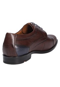 Brown leather dress shoe with a rounded toe, contrasting dark blue heel accent, and detailed stitching along the side.