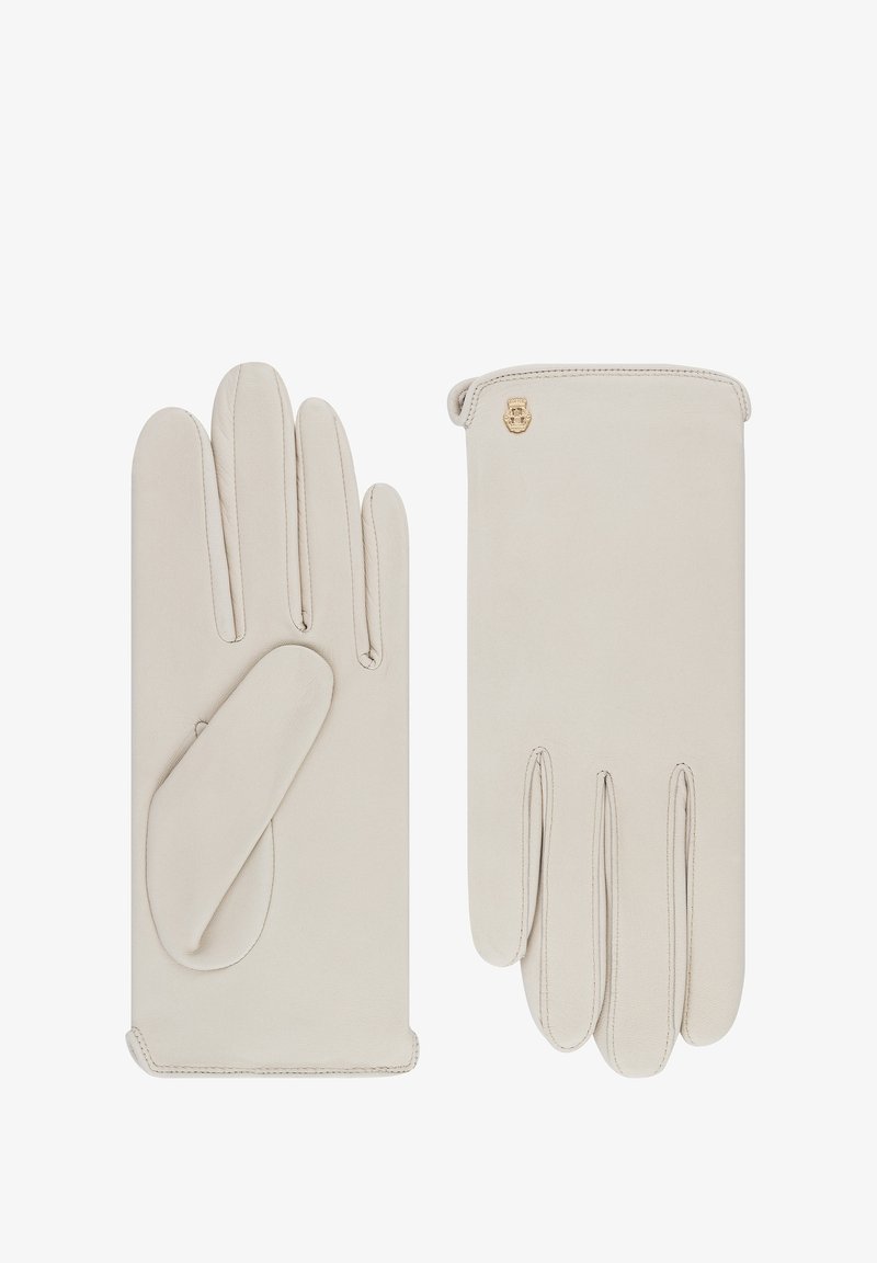 Guantes de cuero beige con una textura suave, que presentan un refuerzo en el pulgar, detalles de costura y un pequeño acento de logo dorado.