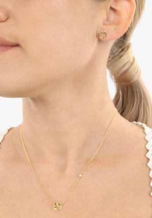 Juego de joyería de oro que incluye pendientes con forma de corazón y un collar a juego con una cadena delicada y un pequeño acento de cristal.