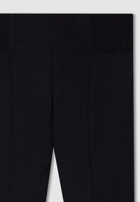 Pantaloni sportivi neri in tessuto liscio con dettagli in rete sulla vita, cuciture strutturate e design aderente.