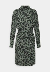 Leopardmönstrad klänning i dämpad grön med lång ärm, krage och ett knytbälte. Tillverkad av ett mjukt, texturerat tyg.