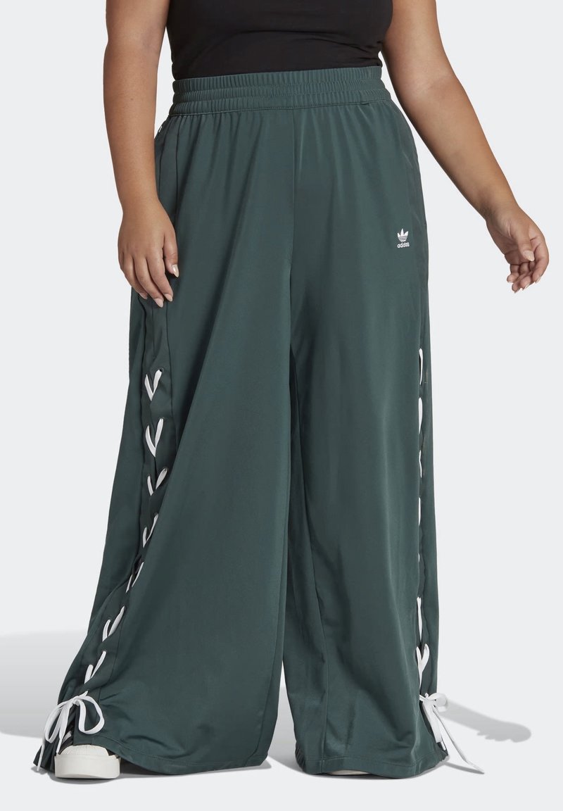 Zelené široké kalhoty vyrobené z hladké látky, s bílým šněrováním po stranách a nařaseným elastickým páskem.