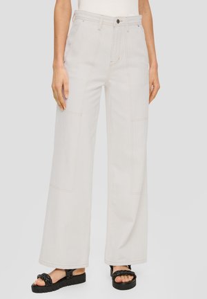 Jeans larghi grigio chiaro realizzati in denim, con cuciture a contrasto, vita alta e due tasche anteriori. Indossati con sandali neri chunky.