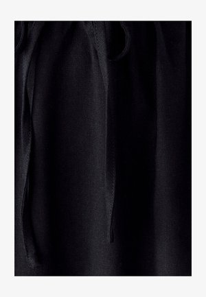Tessuto nero con una superficie liscia, caratterizzato da un design arricciato e lacci con cordoncino. Il materiale appare leggero e elegante.