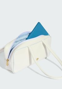 Bijela umjetna torba sa svijetloplavim detaljima, s patentnim zatvaračem i zlatnim logotipom. Unutra se nalazi plavi bilježnica.