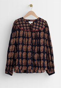 Blusa a maniche lunghe blu navy con motivo paisley rosso e crema, chiusura con bottoni, colletto arrotondato e dettagli arricciati su spalle e polsini.