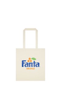 Długa torba z płótna w kolorze kremowym z niebieskim logo "Fanta" oraz pomarańczowymi akcentami, z trzema pomarańczowymi kółkami i zielonym liściem w wzorze.