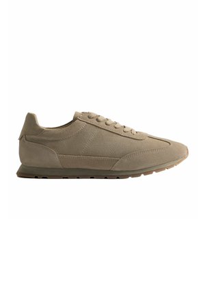 Sneaker beige in suede a profilo basso con chiusura con lacci e suola in gomma testurizzata, progettata per un uso casual.