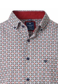 Rode casual overhemd van Redmond met een witte achtergrond, met een geometrisch patroon in rood, blauw en zwart. Het heeft een gespeld kraag en marineblauwe knopen.