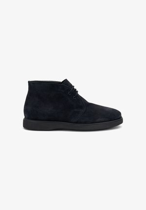 Botines de ante negros con punta redondeada, diseño de cordones y acabado texturizado sobre una suela de goma negra.