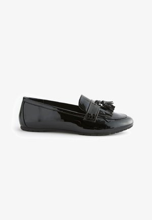 Mocassin en cuir verni noir avec décoration à pampilles sur le dessus, petit talon et semelle en caoutchouc texturée, vu de profil sur fond blanc.